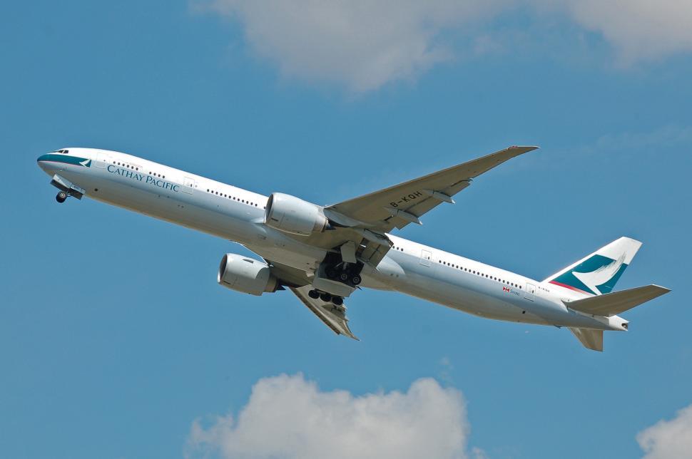 Free Image of Large Jetliner Flying Through Blue Cloudy Sky 