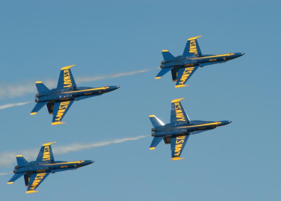 Free Image of Four Fighter Jets Flying in Formation in a Blue Sky 