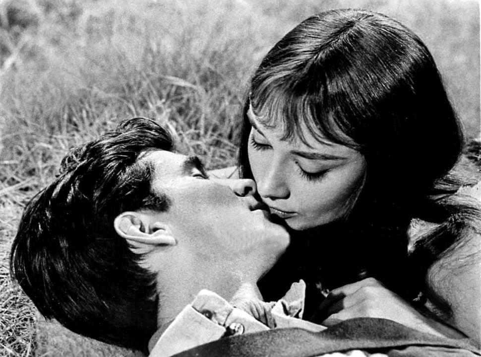 Free Image of Man and Woman Laying in Grass Kissing 