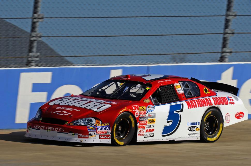 Free Image of Red and White Car Racing Down Race Track 