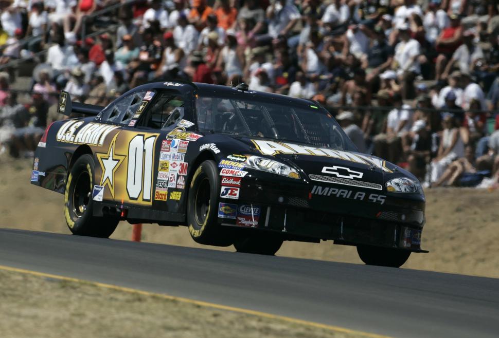 Free Image of Black Car Racing on Track in Front of Crowd 