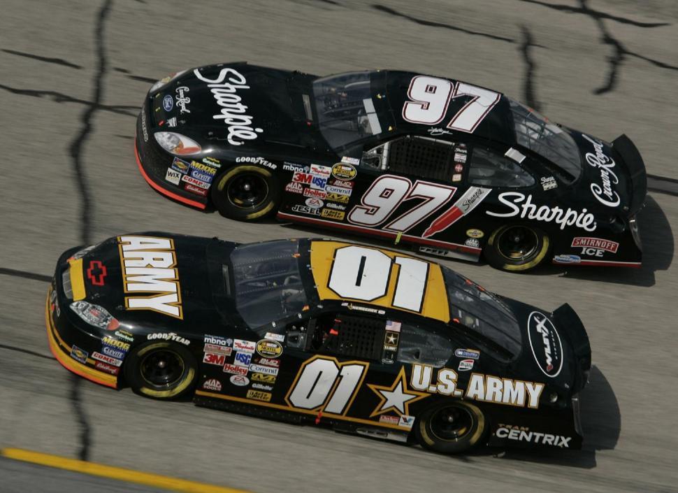 Free Image of Two Racing Cars Driving Side by Side on a Track 