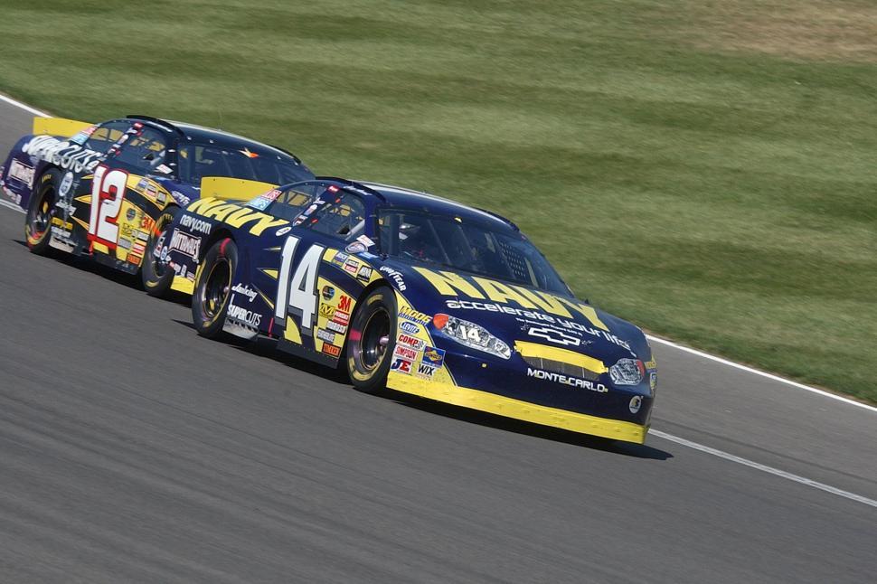 Free Image of Two Cars Racing Down a Track 