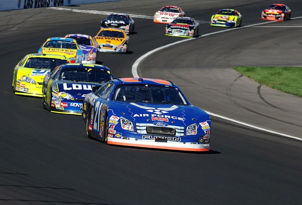 Free Image of Group of Cars Speeding Down Race Track 