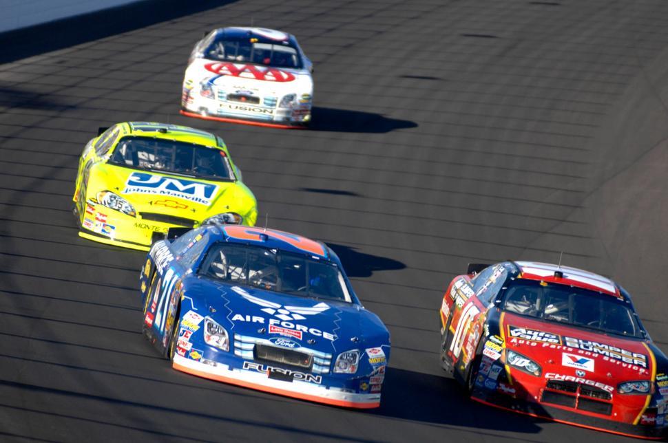 Free Image of Group of Cars Racing Around a Track 