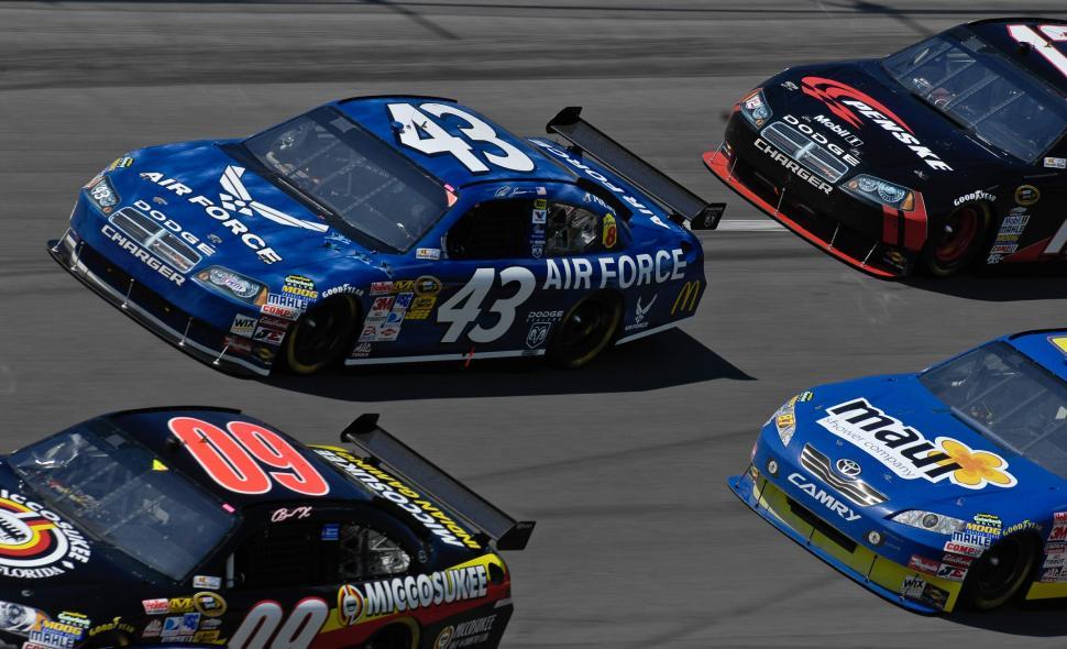 Free Image of Three Racing Cars Speeding Down Race Track 
