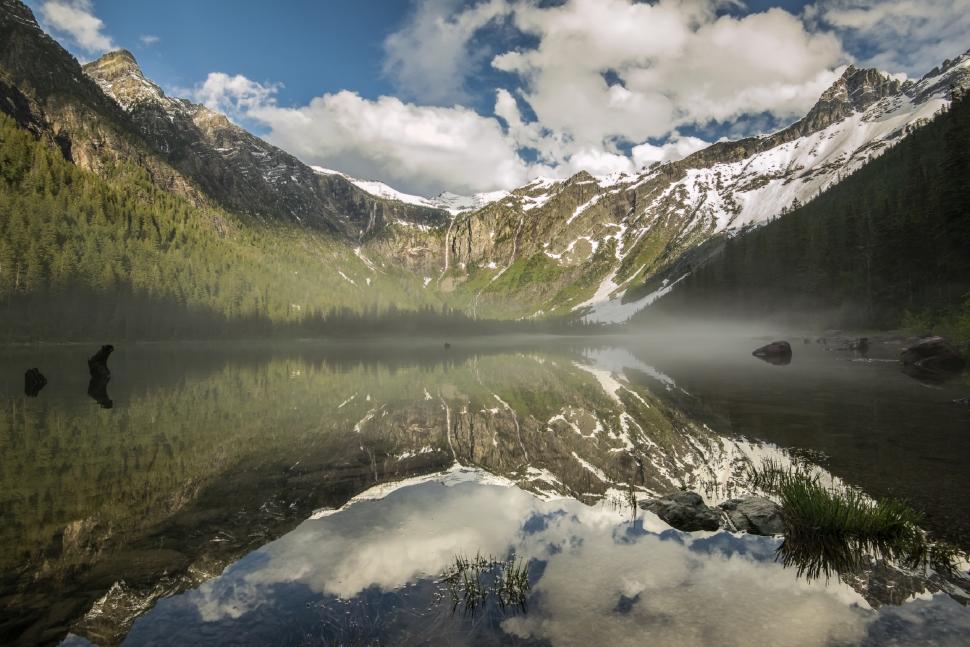 Free Image of Snow-Covered Mountains Surrounding a Lake Under a Cloudy Sky 