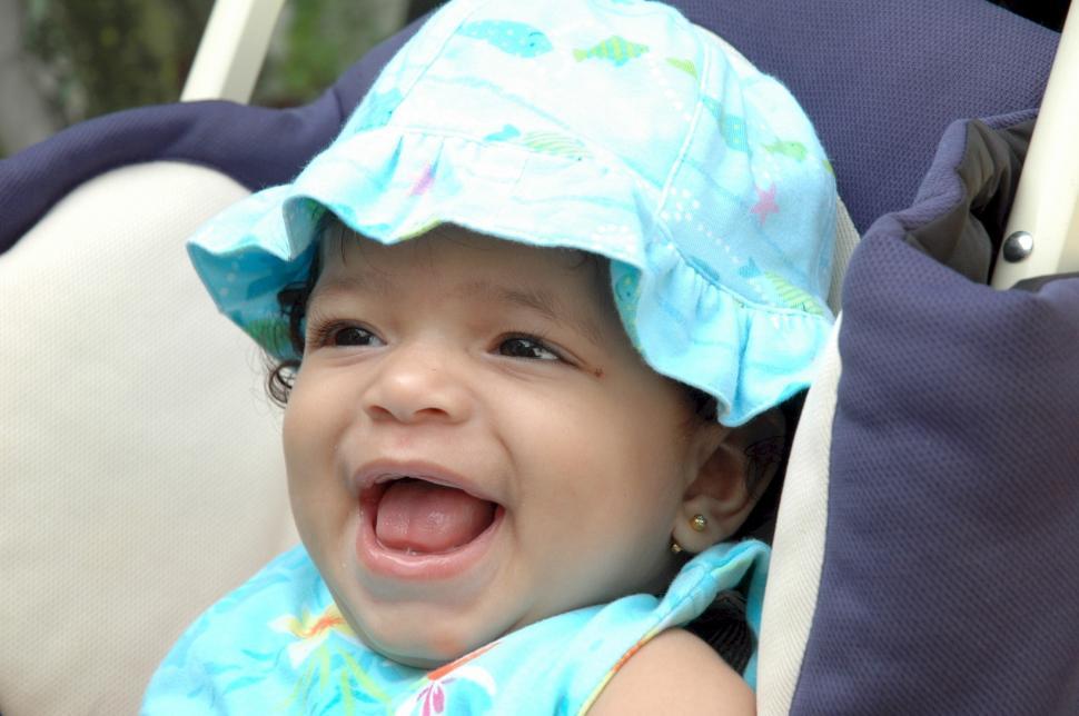 Free Image of Little Girl Sitting in Chair With Hat On 