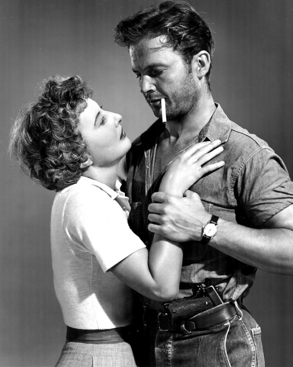 Free Image of Man Standing Next to Woman With Cigarette in Mouth 