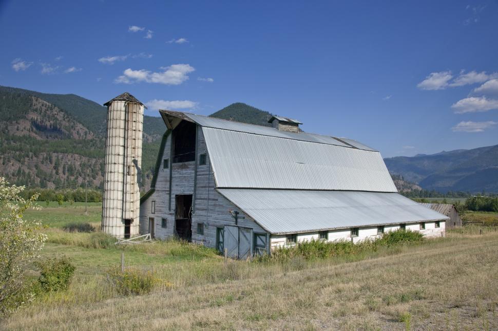 Free Image of Barn in a Field With Mountains in the Background 