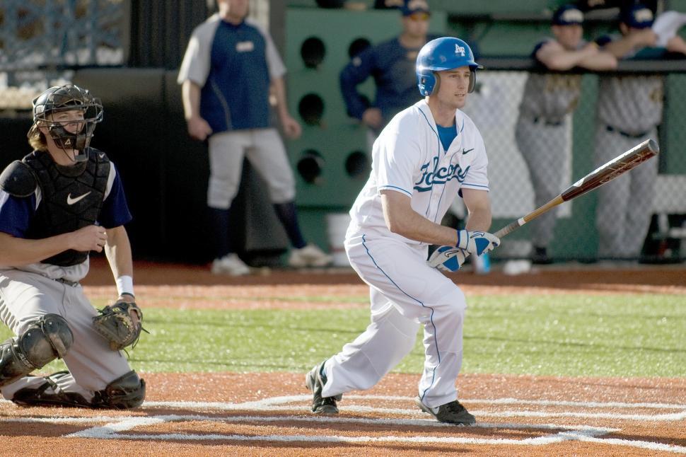 Free Image of Baseball Player Holding Bat Next to Home Plate 