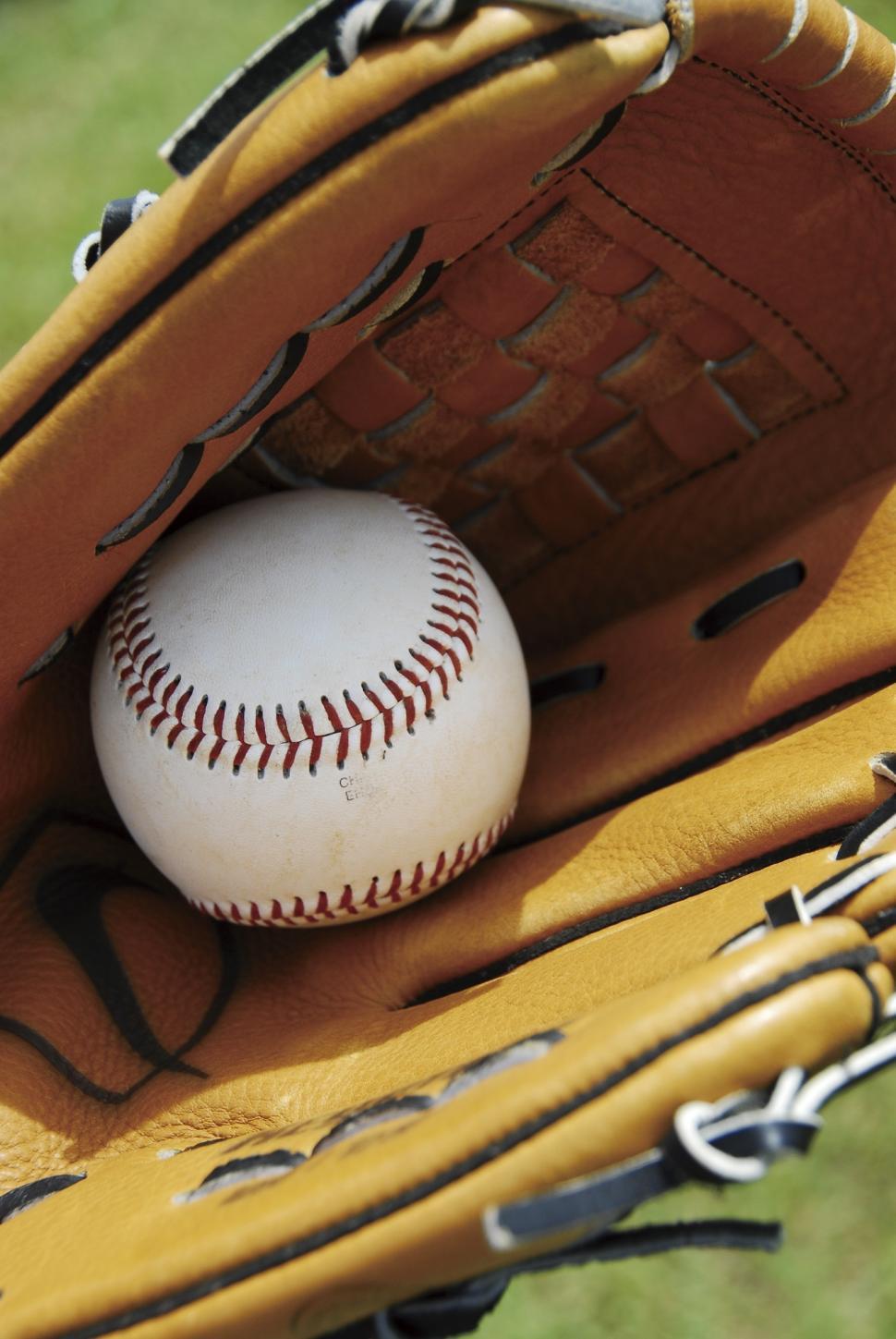 Free Image of Baseball Inside Catchers Mitt on Field 