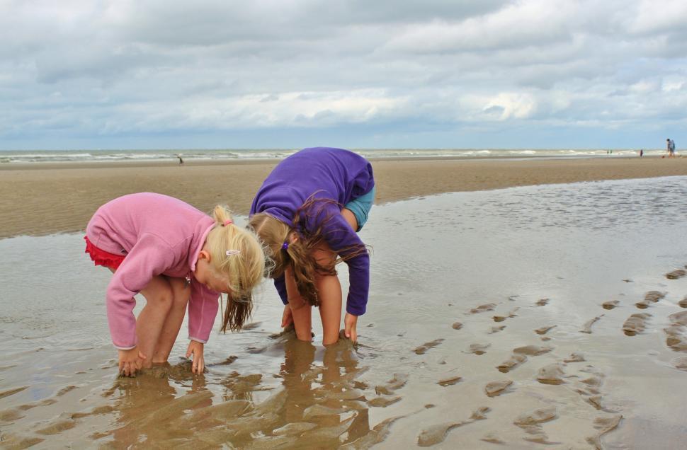 Free Image of Two Little Girls Playing in the Water at the Beach 