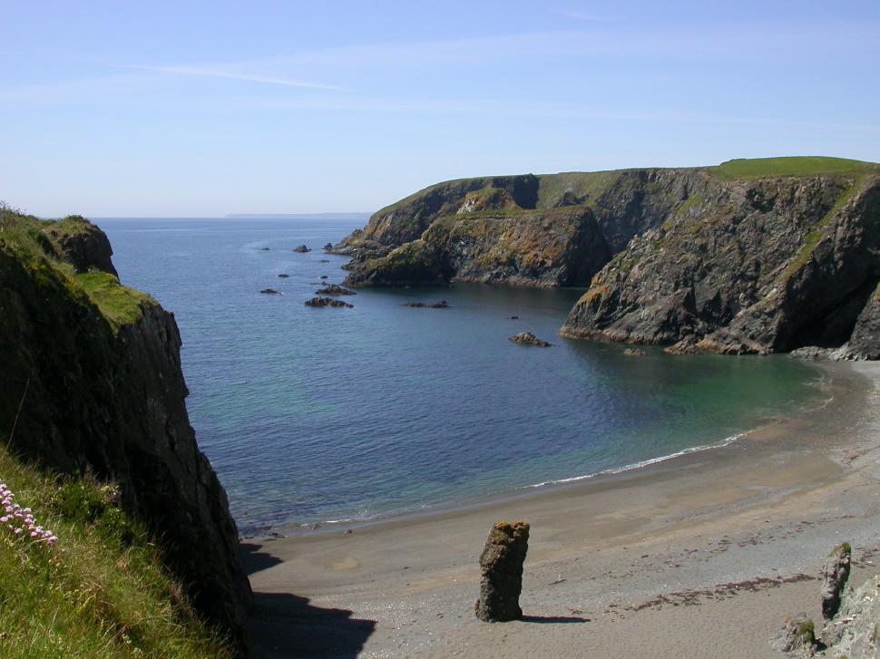 Free Image of Sandy Beach and Cliff by the Water 