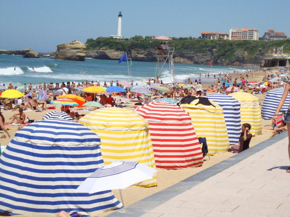 Free Image of Woman Standing on Beach Beside Crowd 