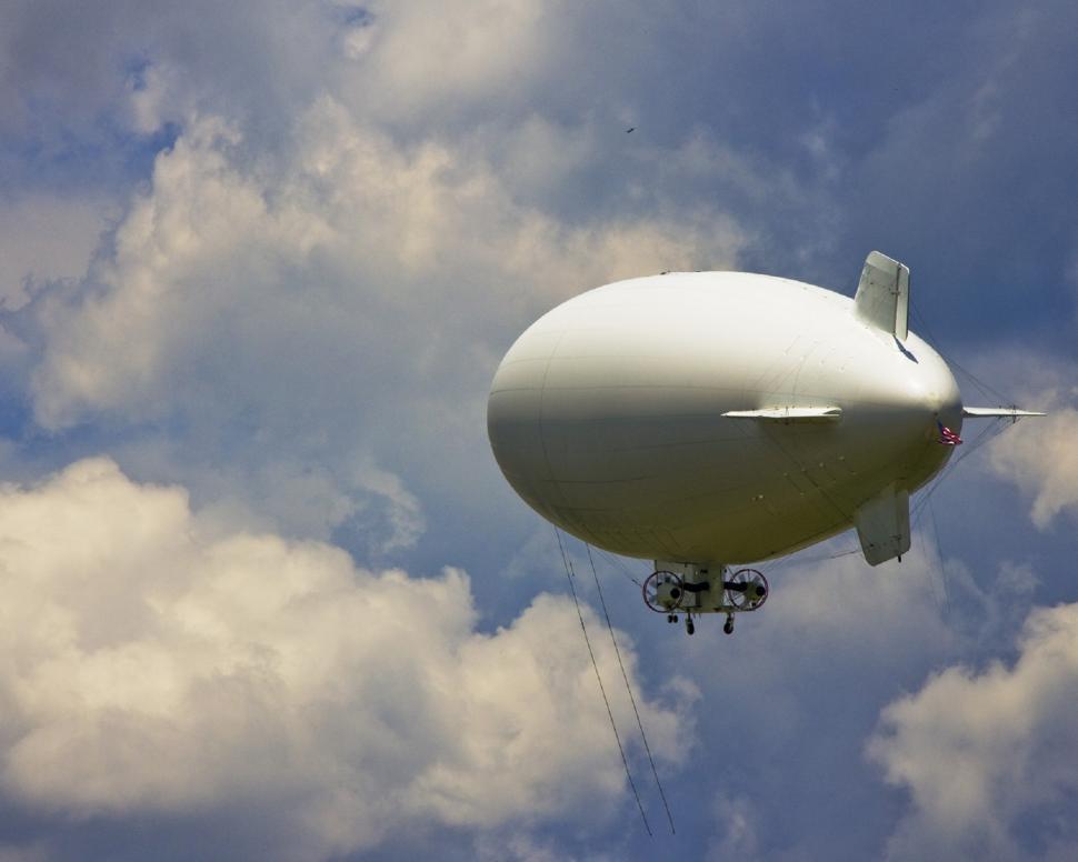 Free Image of Large White Airplane Flying Through Cloudy Blue Sky 