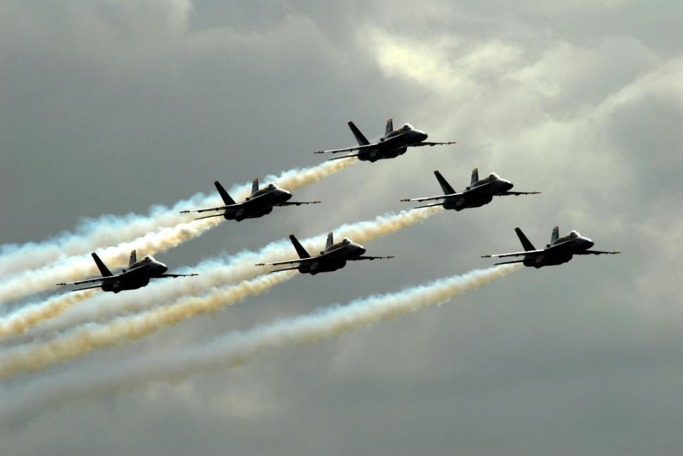 Free Image of Group of Fighter Jets Flying Through Cloudy Sky 
