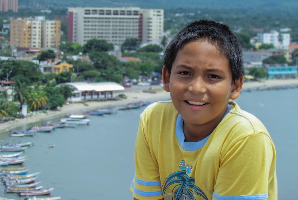 Free Image of Young Boy Standing in Front of Body of Water 