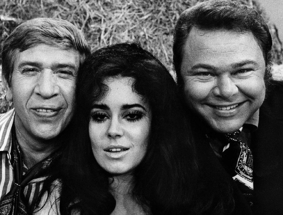 Free Image of Two Men and a Woman Posing for a Picture 