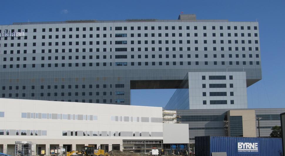 Free Image of Large White Building Next to Parking Lot 