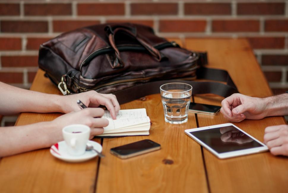 Free Image of Couple Sitting at Wooden Table 