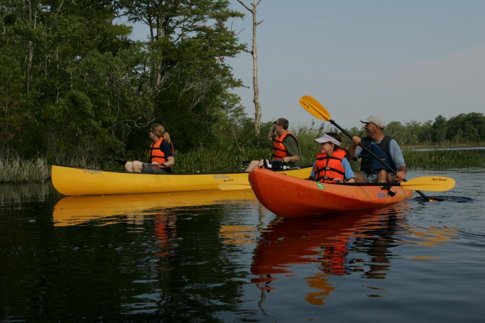 Free Image of Group of People Riding on Top of a Yellow Kayak 