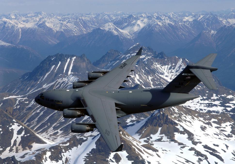 Free Image of Large Airplane Flying Over Mountain Range 