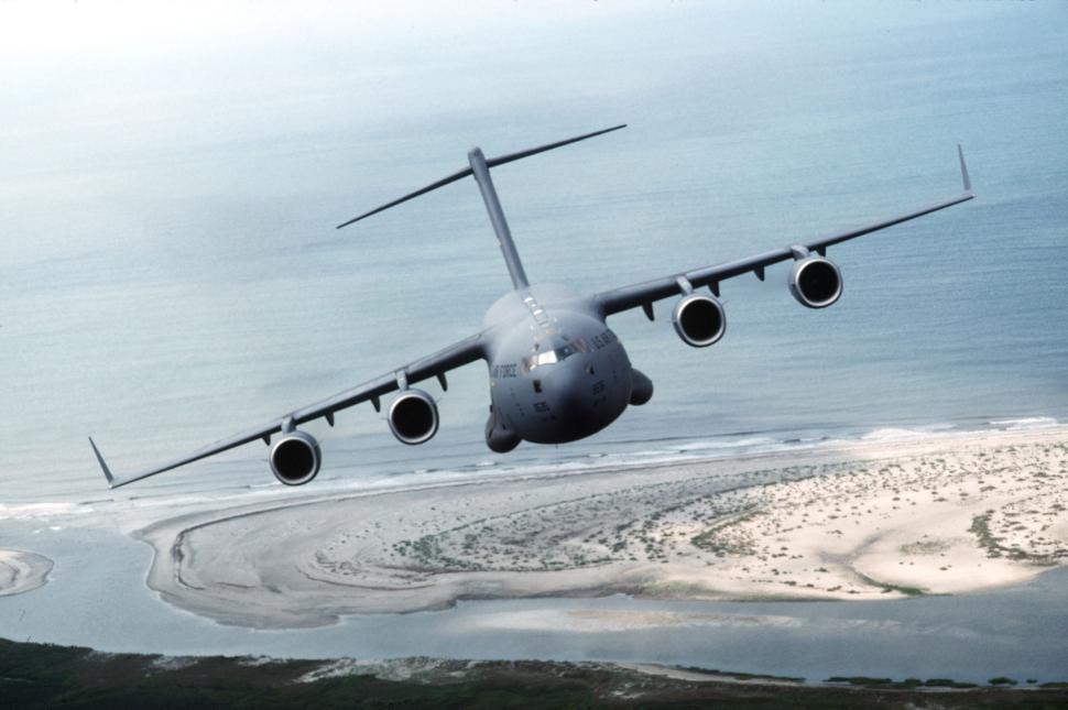 Free Image of Large Airplane Flying Over Beach 