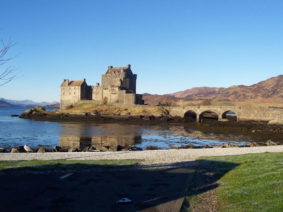 Free Image of Castle Overlooking Lake and Green Field 