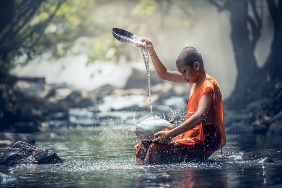 Free Image of Man in Orange Shirt Sitting in Water 