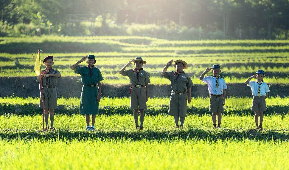 Free Image of Group of People Standing on Top of Lush Green Field 