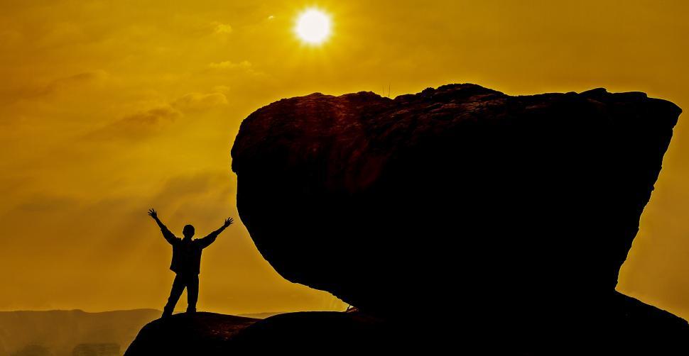 Free Image of Person Standing on Top of Large Rock 