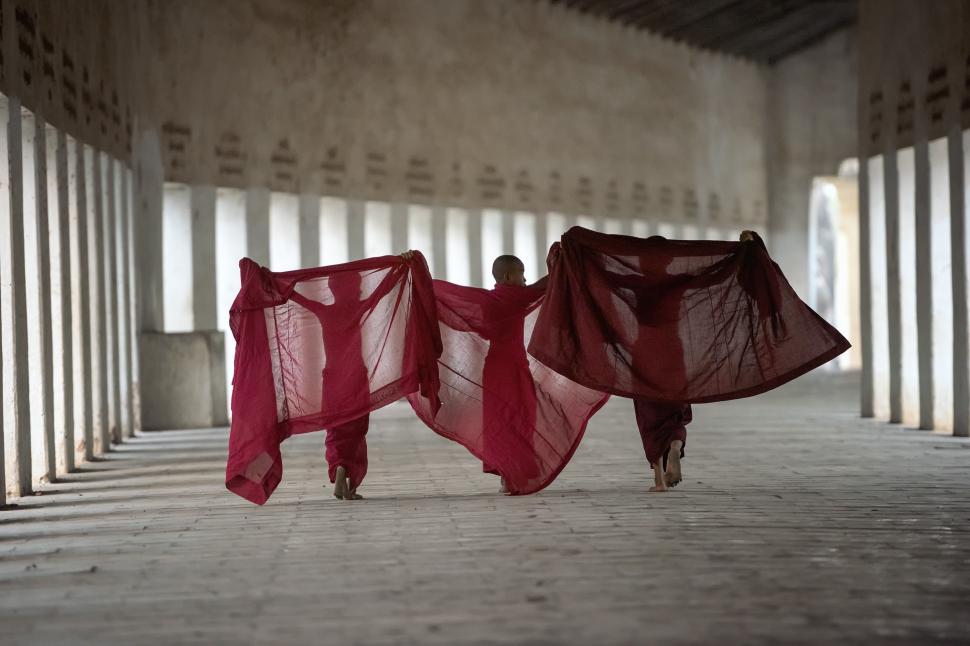 Free Image of Woman in Red Dress Walking Through a Building 