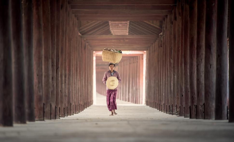 Free Image of Man Carrying Basket Walking Through Tunnel 