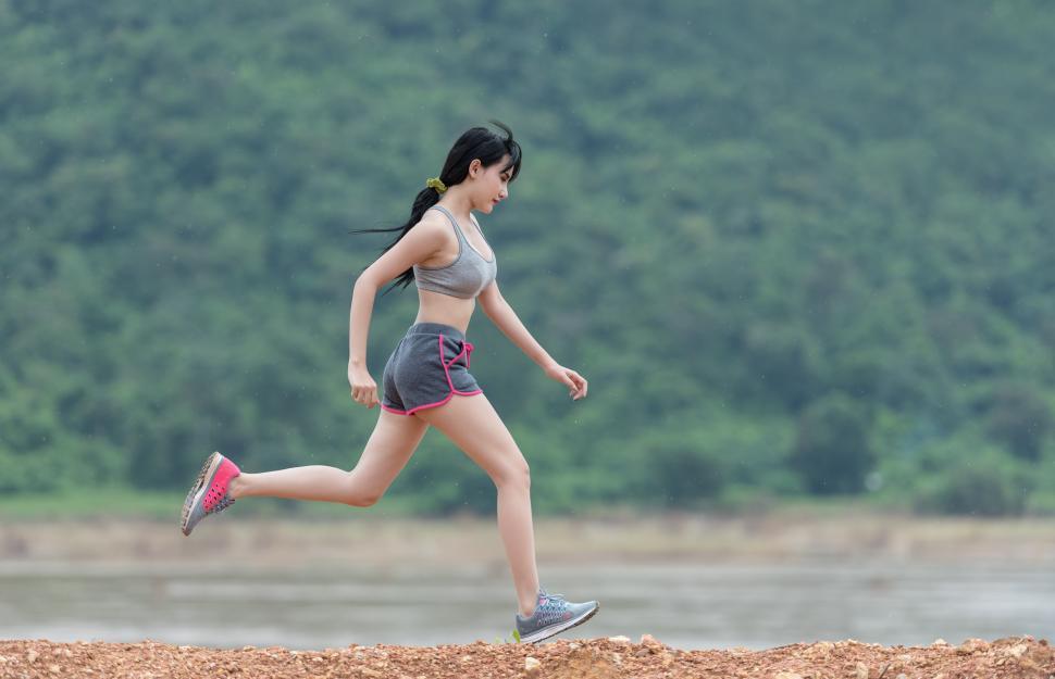 Free Image of Woman Running Across Dirt Field Next to Forest 