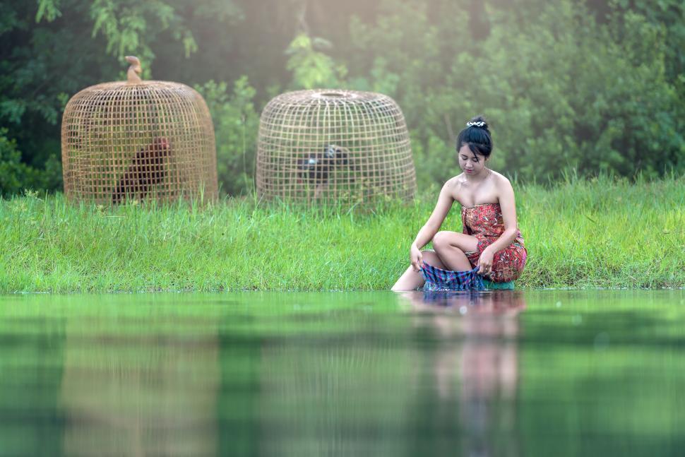 Free Image of Woman Sitting on Rock in Body of Water 