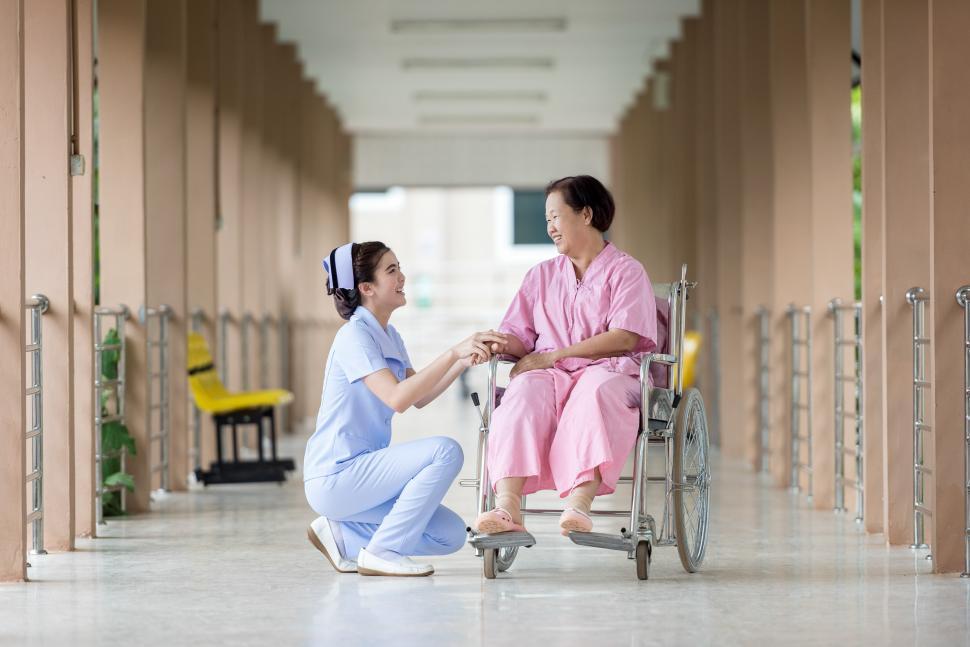 Free Image of Woman in Wheelchair Talking to Man in Pink Shirt 