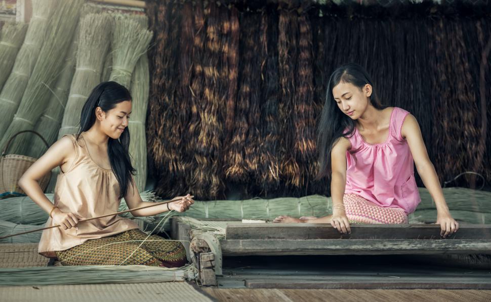 Free Image of Two Women Sitting on a Bed in a Room 