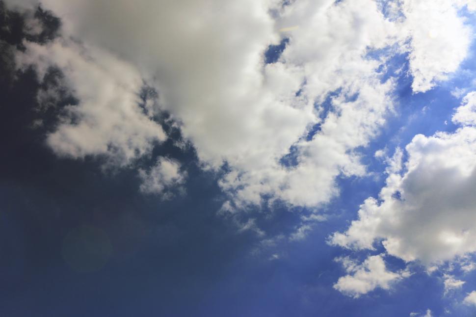 Free Image of Plane Flying Through Cloudy Blue Sky 