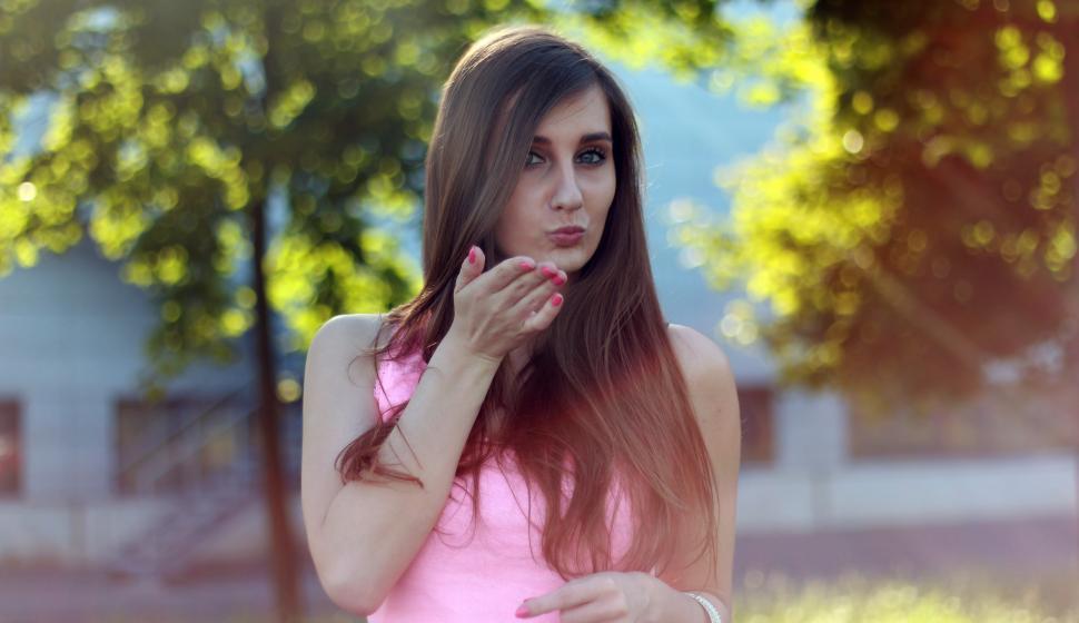 Free Image of Woman in Pink Dress Holding Hand to Face 