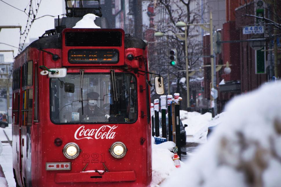 Free Image of Red Train Traveling Down Snow Covered Street 