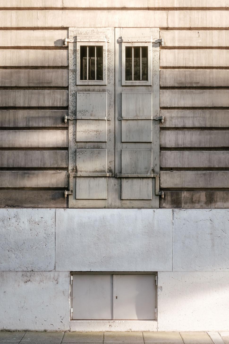 Free Image of Man Walking Down a Street Past a Tall Building 
