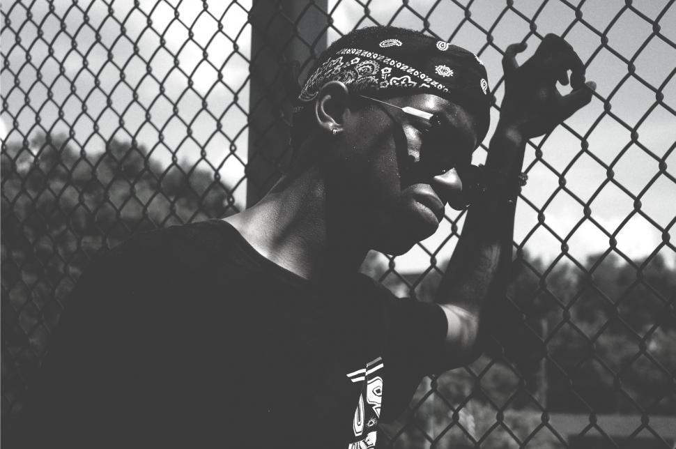 Free Image of Man Standing in Front of Chain Link Fence 