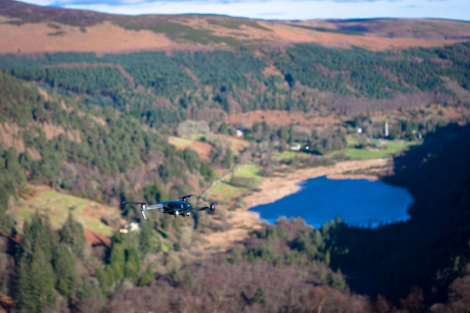 Free Image of Plane Flying Over Lake Surrounded by Trees 