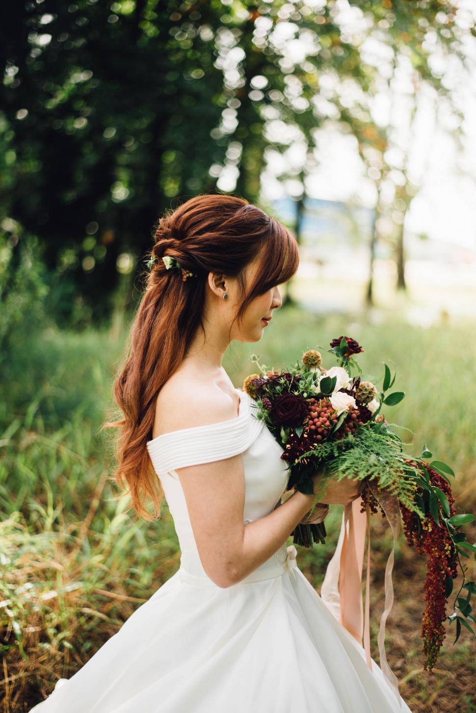 Free Image of Woman in White Dress Holding Bouquet of Flowers 