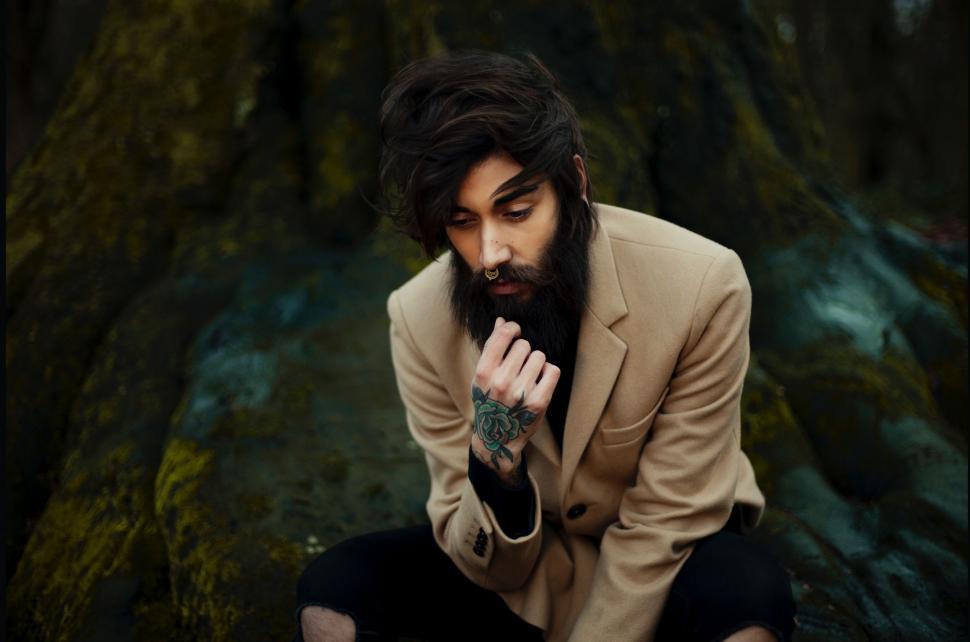 Free Image of Man Sitting on Rock 