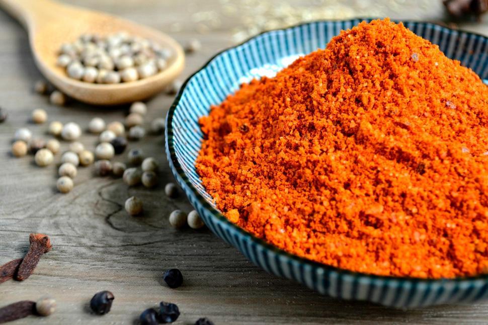 Free Image of Blue Bowl Filled With Red Powder Next to Wooden Spoon 