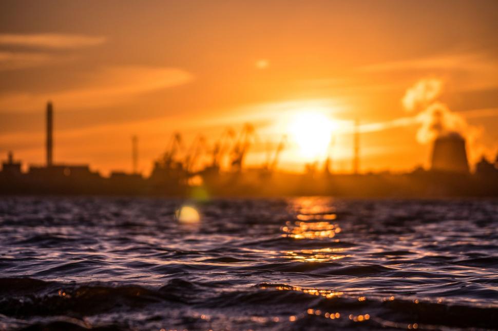 Free Image of Sunset Over Water With Factory in Background 