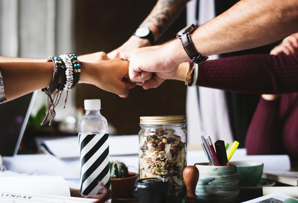 Free Image of Group of People Holding Hands Over a Table 