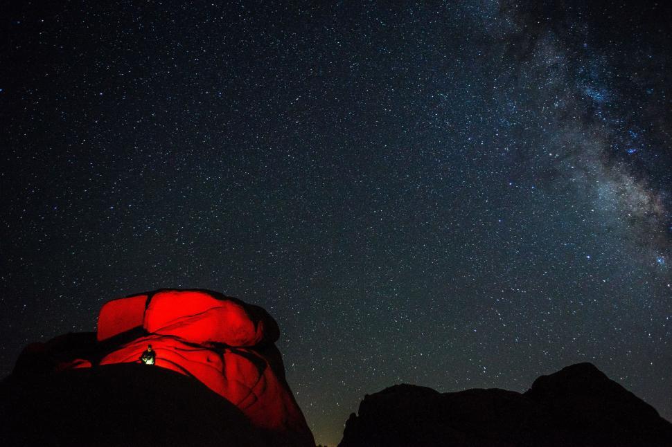 Free Image of Person Camping Under Red Sleeping Bag Beneath Stars 